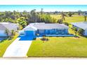 Beautiful home with lush lawn, blue accents, and serene views of the golf course at 16 Golfview Ct, Rotonda West, FL 33947