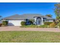 Single-story home with a two-car garage and nicely landscaped lawn at 2 Broadmoor Rd, Rotonda West, FL 33947
