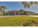 Charming one-story home with mature palms, a circular driveway and spacious three-car garage at 2 Marker Rd, Rotonda West, FL 33947
