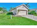 Tan house with a two-car garage and nicely manicured lawn at 3179 Osprey Ln, Port Charlotte, FL 33953