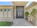 Front entry with double doors, a screened porch, and landscaping at 634 Boundary Blvd, Rotonda West, FL 33947