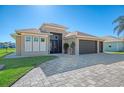 House with a three-car garage, paver driveway, and landscaping at 634 Boundary Blvd, Rotonda West, FL 33947