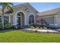 Front entrance with a walkway, arched entryway and landscaping at 76 Long Meadow Ct, Rotonda West, FL 33947