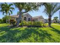 Well-maintained house with lush landscaping and palm trees at 76 Long Meadow Ct, Rotonda West, FL 33947