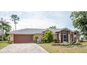 House with a two-car garage and a manicured lawn at 97 Mariner Ln, Rotonda West, FL 33947