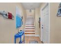 Staircase with light wood treads, white risers, and small entry table at 10390 Longshore Rd # 82, Placida, FL 33946