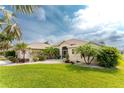 Single story house with a lush green lawn and palm trees at 108 Broadmoor Ln, Rotonda West, FL 33947