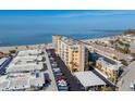 Aerial view of beachfront building and parking lot with ocean view at 1255 Tarpon Center Dr # 303, Venice, FL 34285