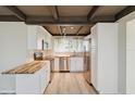 Bright kitchen with stainless steel appliances, butcher block countertops, and wood beam ceiling at 1305 Rocky Creek Ln, Englewood, FL 34224