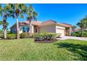 Exterior view of a single-story house with tile roof, landscaping and a paved driveway at 13091 Creekside Ln, Port Charlotte, FL 33953