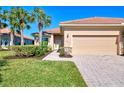 Single-story house exterior with light beige walls, tile roof, and a two-car garage at 13091 Creekside Ln, Port Charlotte, FL 33953
