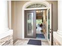 Inviting foyer with decorative glass front door, high ceilings, and open view to living area at 14010 San Domingo Blvd, Port Charlotte, FL 33981