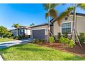 Single story home with gray garage door and nicely landscaped yard at 19584 Fishhawk Trl, Venice, FL 34293