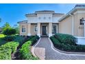 Inviting front entry with brick walkway and landscaping at 26852 Faldo Ln, Englewood, FL 34223