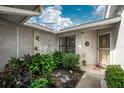 Inviting courtyard entry with lush landscaping and decorative accents at 313 Pembroke Lane North # 195, Venice, FL 34293