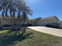 House exterior showcasing a driveway and palm trees at 89 Caddy Rd, Rotonda West, FL 33947