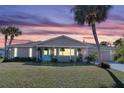 Inviting home at sunset, showcasing the front yard and landscaping at 9487 Prospect Ave, Englewood, FL 34224
