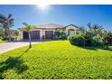 House with a large yard, palm trees, and a three-car garage at 109 Bonita Dr, Rotonda West, FL 33947