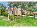 One story house with tan exterior, landscaping, and palm trees at 13123 Preserve Ct, Port Charlotte, FL 33953