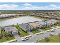 An aerial view of a residential community with single-Gathering homes, green lawns, and a pond at 15137 Spanish Point Dr, Port Charlotte, FL 33981