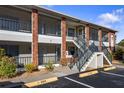 Condo building exterior showcasing a brick facade, stairs, and screened balconies at 1531 Placida Rd # 1-204, Englewood, FL 34223