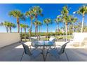 Relaxing balcony with table and chairs, overlooking lush tropical landscape at 1651 Beach Rd # 212, Englewood, FL 34223