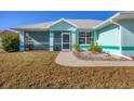 Light teal home with screened porch and landscaped yard at 2271 Paraiso Ct, Englewood, FL 34224