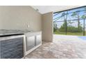 Covered patio with built-in grill, wine cooler, and screened enclosure overlooking a pool at 35 Broadmoor Ln, Rotonda West, FL 33947