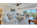 Bright living room with white slipcovered furniture and water views at 5856 Gasparilla Rd # M27, Boca Grande, FL 33921