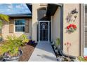 Front entry with decorative metal door and landscaping at 6128 Catalan St, Englewood, FL 34224