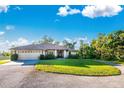 Charming single-story home with a welcoming front yard, mature trees, and circular driveway at 6375 Biggs St, Englewood, FL 34224