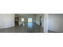 Spacious living room with tiled floors leading to the kitchen and sliding glass door entrance at 7351 Lighthouse St, Englewood, FL 34224
