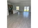 Bright, open-concept living room and kitchen with tile flooring and sliding glass doors at 7351 Lighthouse St, Englewood, FL 34224