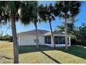Screened patio and lush lawn with palm trees in the backyard at 7472 Stetson Ln, Port Charlotte, FL 33981
