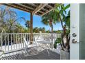 Relaxing outdoor deck with white chairs and table, overlooking lush tropical foliage at 7482 Palm Island Dr # 2511, Placida, FL 33946