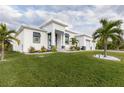 White single-story home with teal front door, landscaping, and a three-car garage at 8198 Clyde Cir, Port Charlotte, FL 33981