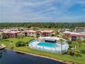 An aerial view showcasing the community pool, waterfront access, and surrounding greenery at 84 Boundary Blvd # 165, Rotonda West, FL 33947
