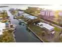 Aerial view showcasing a single-story home with a detached garage and canal views at 9230 Griggs Rd, Englewood, FL 34224