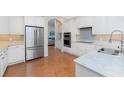 Modern kitchen featuring white cabinets, stainless steel appliances, and light countertops at 112 Abercrombie Ave, Englewood, FL 34223