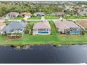 Aerial view showcases waterfront homes with private pools and screened patios bordering a wide canal at 171 Medalist Rd, Rotonda West, FL 33947