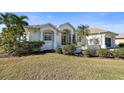 Inviting single-Gathering home with lush landscaping, palm trees, and a covered garage at 385 Pelican Bnd, Placida, FL 33946