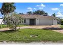 Traditional single-story home featuring a two-car garage and a well-maintained lawn at 560 Sandlor Dr, Englewood, FL 34223