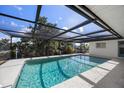 Screened-in swimming pool with clear blue water, perfect for relaxation and entertainment at 560 Sandlor Dr, Englewood, FL 34223