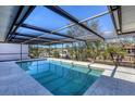 Inviting pool area enclosed by a screened lanai overlooking the water at 560 Sandlor Dr, Englewood, FL 34223