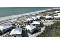 Stunning aerial view of beachfront properties with white roofs, and beach access at 7478 Palm Island Dr # 2611, Placida, FL 33946