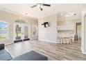 Bright living room with wood floors, a ceiling fan, and sliding glass doors to the backyard at 792 Lehigh Rd, Venice, FL 34293