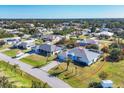 An aerial view of a blue house with a gray roof, in the middle of a residential neighborhood at 9131 Berendo Ave, Englewood, FL 34224