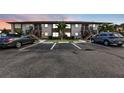 Exterior view of condo building at dusk with parking spaces in front at 25100 Sandhill Blvd # B-103, Punta Gorda, FL 33983