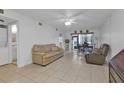 Living room with beige couches, tiled floors, and access to kitchen and dining at 25100 Sandhill Blvd # B-103, Punta Gorda, FL 33983