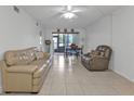 Living room with beige couches, tiled floors, and access to kitchen and dining at 25100 Sandhill Blvd # B-103, Punta Gorda, FL 33983